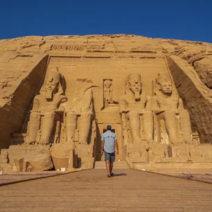 A young man walking towards the Abu Simbel Temple in southern Egypt in Nubia next to Lake Nasser. Temple of Pharaoh Ramses II, travel lifestyle