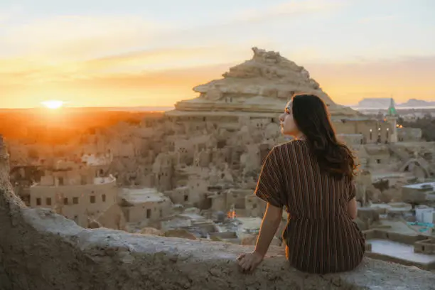 Woman looking at scenic view of Siwa oasis at sunset